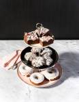 Dessert tower with donuts, cookies, and fudge on a marble table top