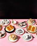 Multiple plates of desserts on a pink paper-lined table