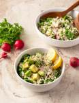 two bowls of couscous salad on a marble background